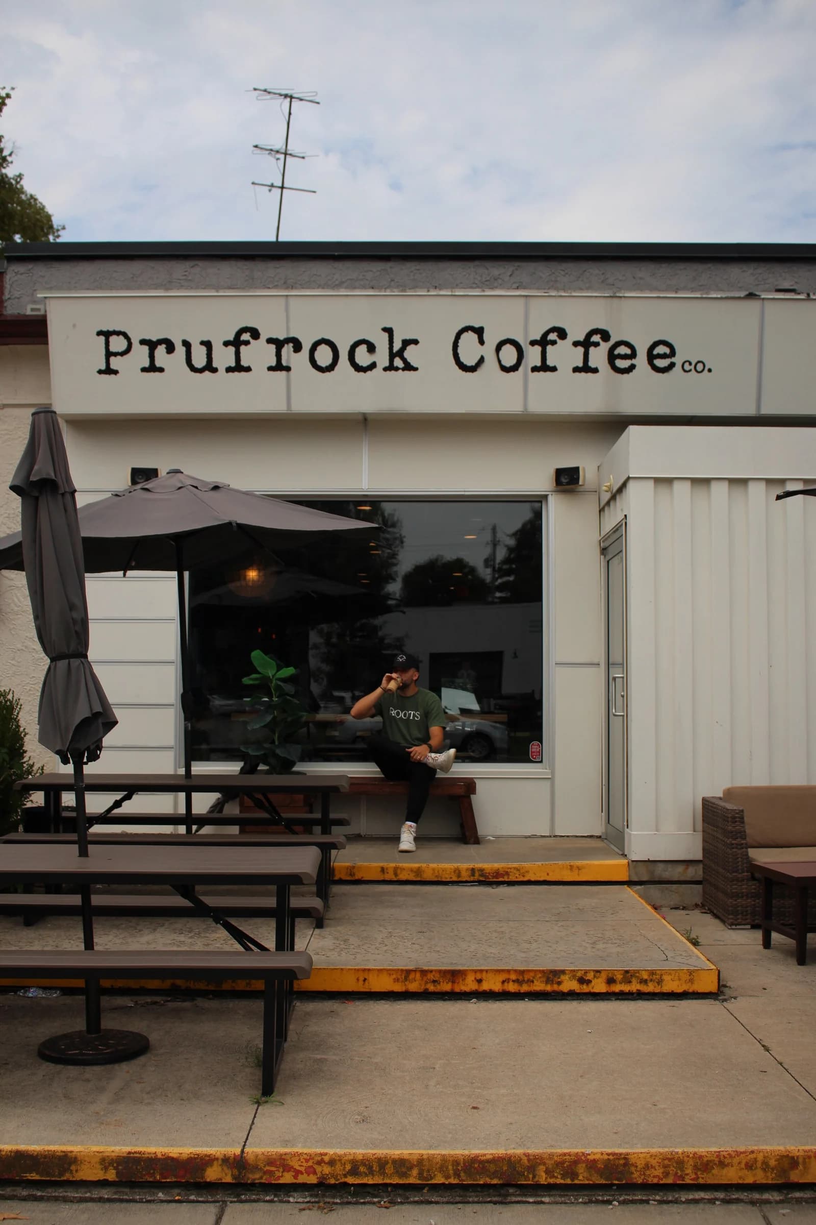 Kyle Hoffman sitting on a bench outside a coffee shop
